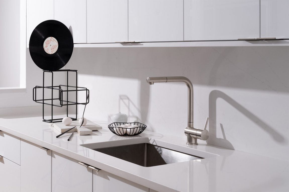 South Park Tower kitchen with glossy white cabinets, Caesarstone countertops, and Blomberg stainless steel appliances
